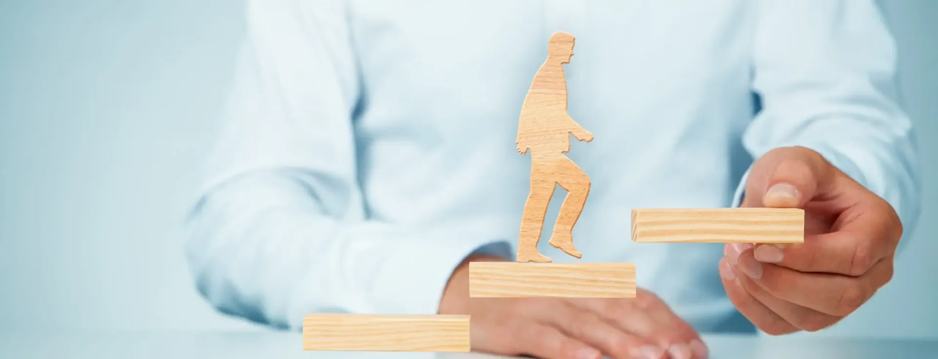 Visuel d'Athanor : une figurine en bois gravit des marches, symbole de progression