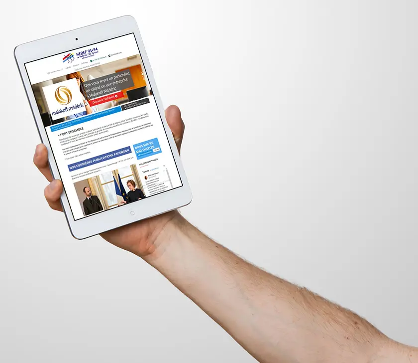 Site du MEDEF 93+94 sur une tablette tenue à bout de bras